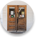 Close up photo of two wooden store doors that are side-by-side