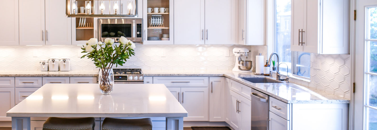 beautiful newly renovated kitchen with white cabinets and vase of white roses on kitchen island