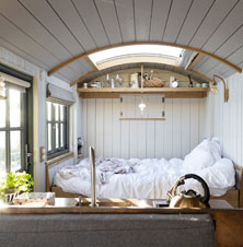 Interior photo of a tiny home with white paneled wooden walls and ceiling