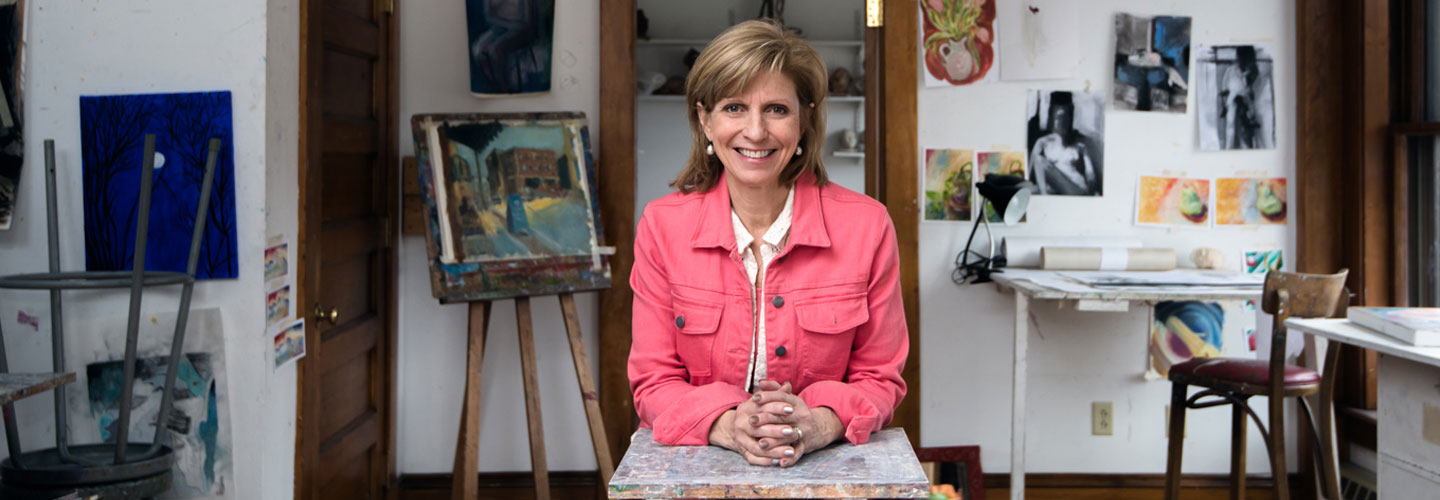 smiling woman sitting in an artist's studio
