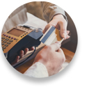 Close up photo of person's hand holding credit card and handing it to another person's hand