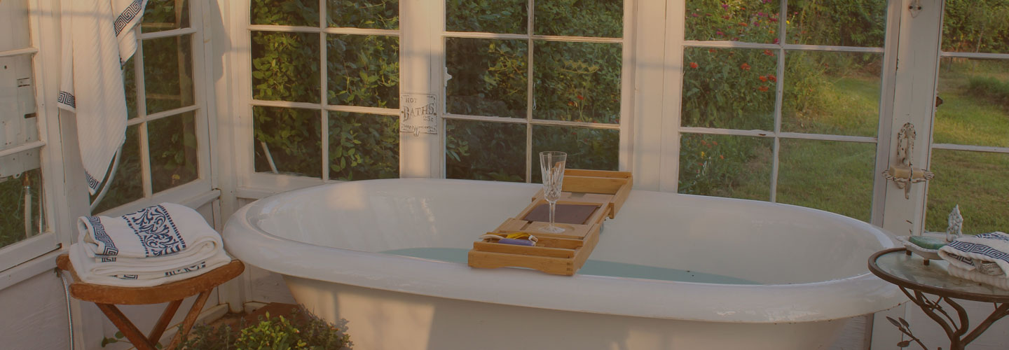 luxurious claw foot bathtub in beautiful bathroom with large windows overlooking tranquil backyard