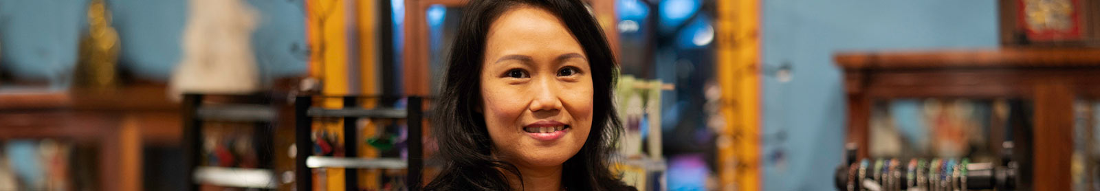 Smiling woman with retail store background behind her