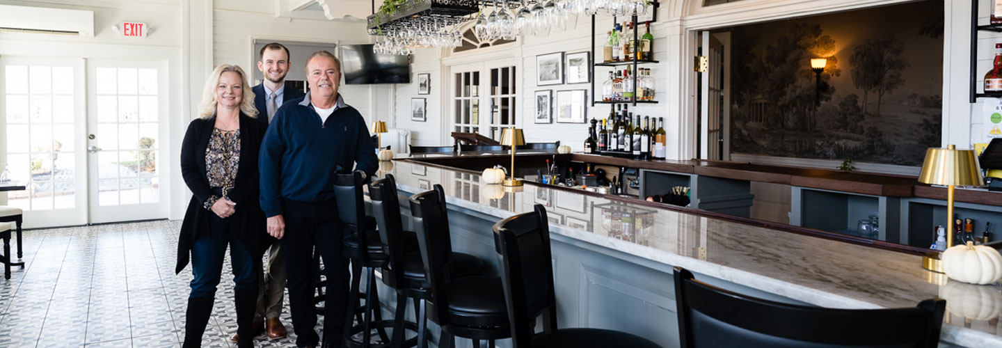 Small business owners standing near a beautiful bar with BS&L banker Robert Davis at the White House Inn of Wilmington