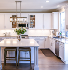 Beautiful white kitchen with vase of flowers on kitchen island