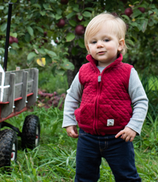 Photo of a toddler wearing a red vest