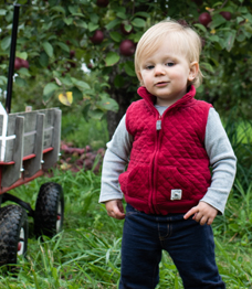 Photo of a toddler wearing a red vest